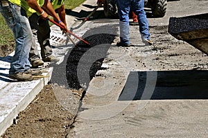 Spreading asphalt on curb repair project