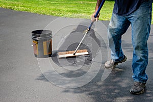 Spreading asphalt in home driveway