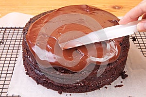 Spreading chocolate ganache on the cake