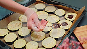 Spreading a filling of spices and olive oil on eggplant