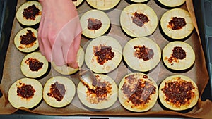 Spreading a filling of spices and olive oil on eggplant