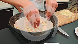 Spreading grated cheese into the pan on top of the sausage