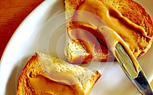 Spreading natural peanut butter on toast