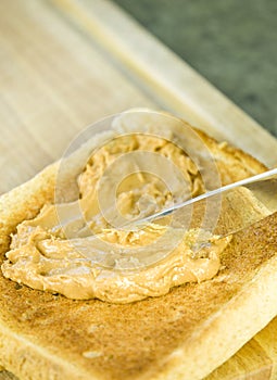 Spreading peanut butter on toast