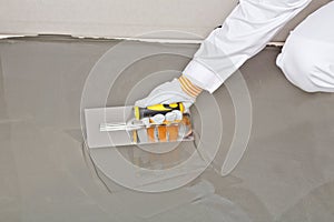 Spreading self leveling compound with trowel photo