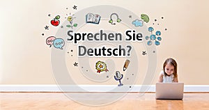 Sprechen Sie Deutsch text with little girl using a laptop computer photo