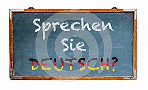 â€œSprechen Sie Deutsch?â€ in German language, Do you speak German? written on a wide blue old grungy vintage wooden chalkboard