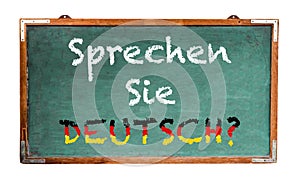 â€œSprechen Sie Deutsch?â€ in German language, Do you speak German? written on a wide green old grungy vintage wooden chalkboard