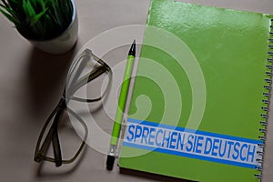 Sprechen Sie Deutsch write on a book isolated on Office Desk. German language it means do you speak german