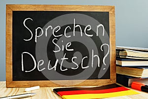 Sprechen Sie Deutsch written on a blackboard. Learn German.