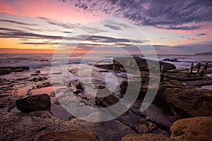 SPretty snrise reflected in ocean rock pools by the beach