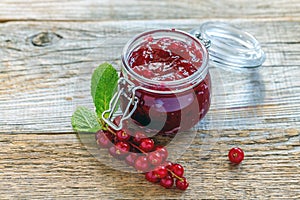 Sprig of red currants and a jar of homemade jam.