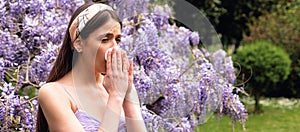 Spring allergy, flu. Banner. Girl with nose allergy sneezing. Polen illnes symptom concept. Woman allergic to blossom