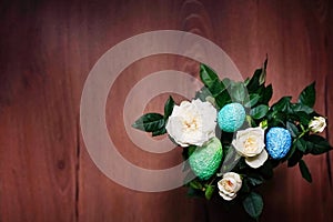 Spring arrangement of rose flowers with multi-colored Easter eggs