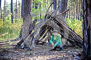 In the spring or autumn in the pine forest the boy plays he buil