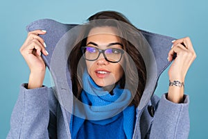 Spring autumn portrait of a woman in a blue knitted sweater, scarf and gray coat