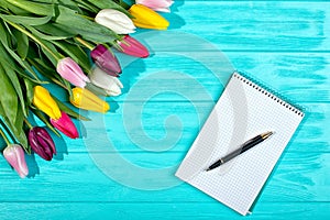 Spring background!A bouquet colorful tulips and an empty notebook for romantic entries.