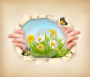 Spring background with hands, ripping paper to show a landscape.