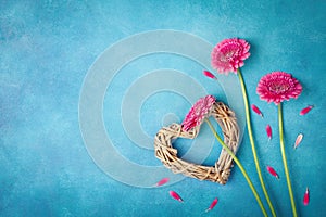 Spring background with pink flowers, heart and petals. Greeting card for Woman day. Flat lay style. Top view.