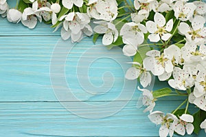 Spring background with white flowers blossoms on blue wooden background. top view