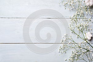 Spring background. White rustic flowers on blue wooden table. Banner mockup for womans or mother day, happy easter, spring holiday