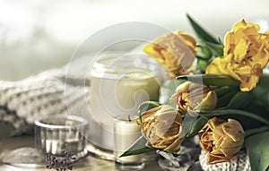 Spring background with yellow tulips, candles and knitted element.