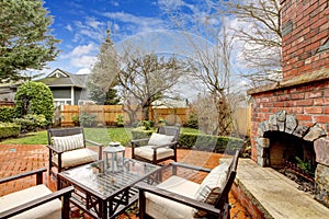 Spring backyard with outdoor fireplace and furniture.