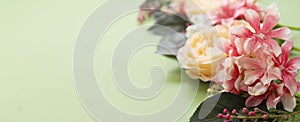 Spring baner frame with flower composition on green board. Festive frame or border. Top view with copy space