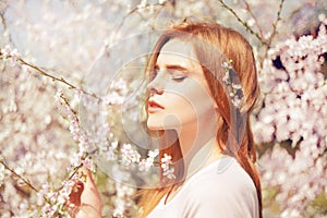 Spring beauty girl with long hair outdoors. Blooming trees. Romantic young woman portrait. Nature. Beauty Girl Portrait.