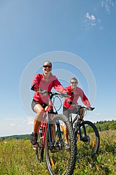 Spring bike - Young sportive couple in meadow