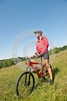 Spring bike - Young sportive woman in meadow
