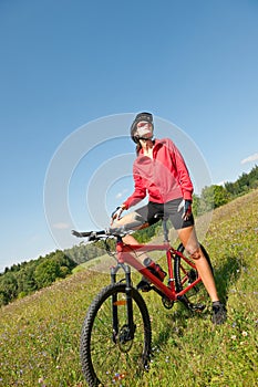 Spring bike - Young sportive woman in meadow