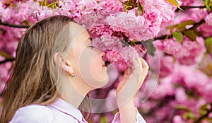 Spring in botany garden. That is how spring smells. Tender bloom. Little girl enjoy spring. Kid on pink flowers of