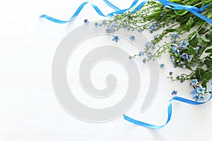 Spring bouquet of blue and delicate blue flowers over white wooden background. top view, flat lay