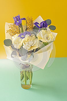 Spring bouquet of flowers. Irises, tulips, mimosa and eucalyptus. Yellow and blue flower. Bud close-up. Floral