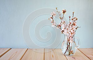 Spring bouquet of flowers on the wooden table with mint background. vintage filtered image