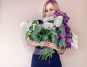 Spring bouquet of lilacs in woman hands. Woman portrait .