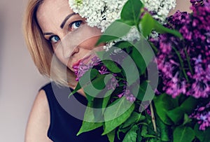 Spring bouquet of lilacs in woman hands. Woman portrait .