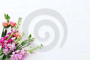 Spring bouquet of pink flowers over white vintage wooden background. top view, flat lay