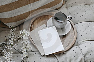 Spring breakfast scene. Blank greeting card, invitation mockup. Cup of coffee, round wooden tray. Blossoming cherry plum