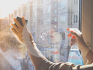 Spring cleaning - cleaning windows. Women`s hands wash the window, cleaning