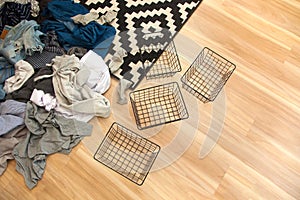 Spring cleaning of closet. Vertical tidying up storage. Neatly folded clothes in the metal black baskets for wardrobe. Wooden