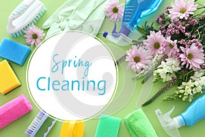 Spring cleaning concept with supplies over pastel green wooden background. Top view, flat lay