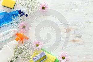 Spring cleaning concept with supplies over white wooden background. Top view, flat lay