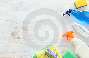 Spring cleaning concept with supplies over white wooden background. Top view, flat lay
