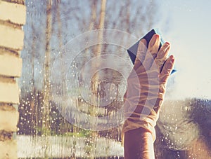 Spring cleaning - cleaning windows. Women`s hands wash the window, cleaning