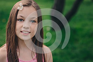 Spring closeup outdoor portrait of adorable 11 years old preteen kid girl