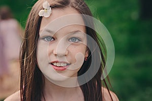 Spring closeup outdoor portrait of adorable 11 years old preteen kid girl