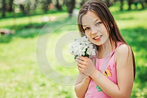 Spring closeup outdoor portrait of adorable 11 years old preteen kid girl