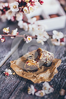 Spring collection of handmade chocolate bonbons candies and cherry flowers decoration on rustic wooden background